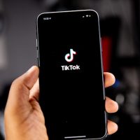 hand holding phone that is displaying tiktok logo