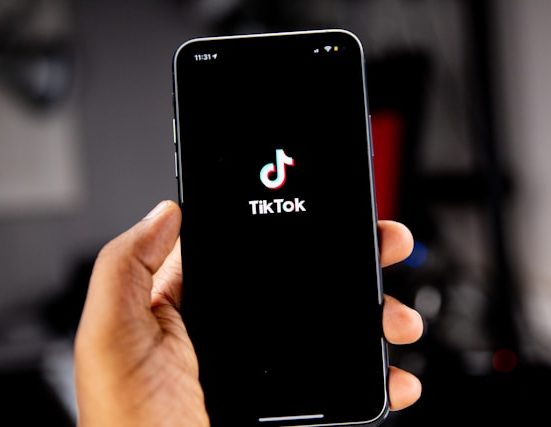 hand holding phone that is displaying tiktok logo