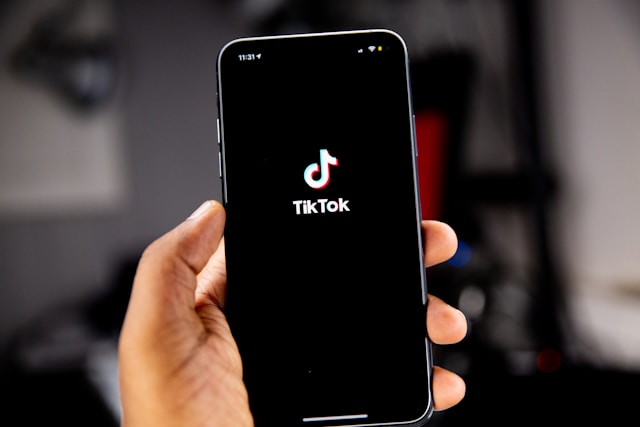 hand holding phone that is displaying tiktok logo