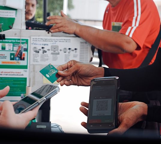 A man holding a phone and credit card at checkout